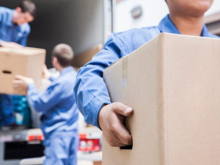 movers carrying boxes into a moving truck